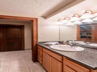 This bathroom features a stylish vanity with ample storage, perfect for keeping your essentials organized.