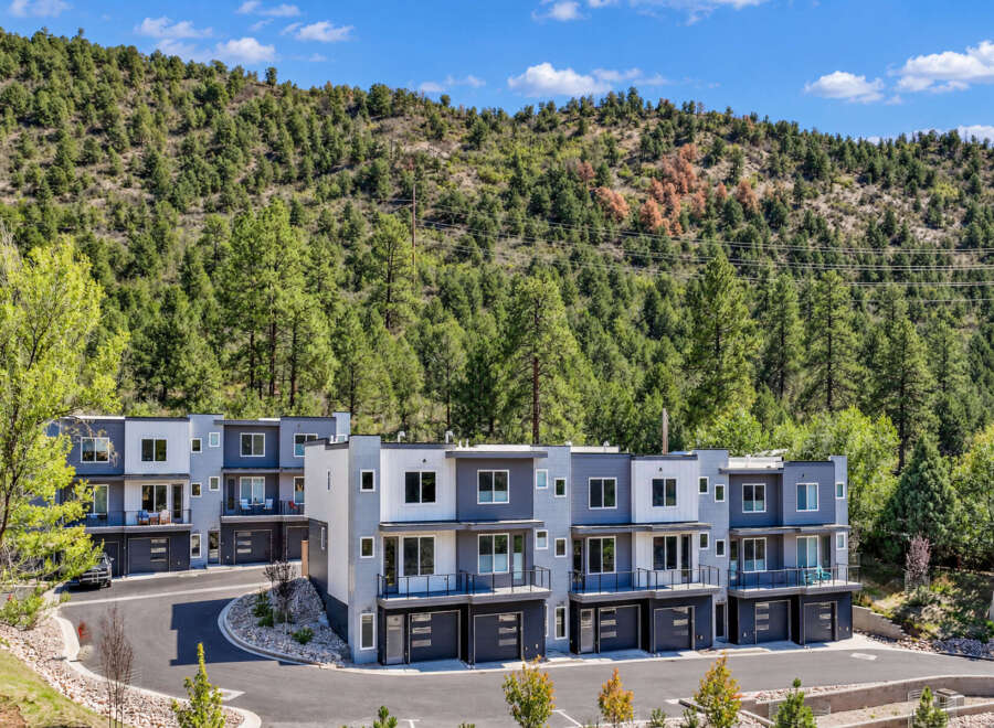 Discover modern living in this stunning townhome development nestled against a lush, tree-covered mountainside.