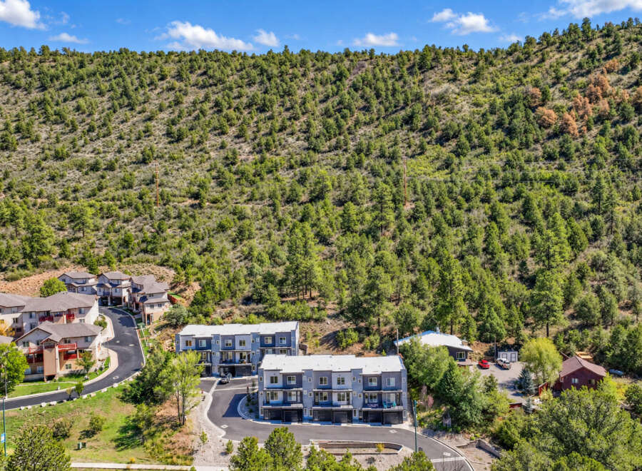 Discover modern living nestled against a backdrop of lush green hills.