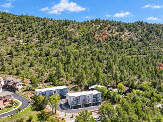 Discover modern living nestled against a backdrop of lush green hills and a clear blue sky.