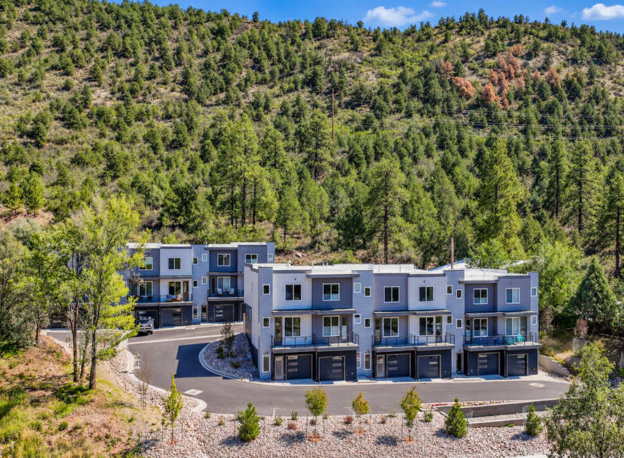 Discover modern living in this stunning townhouse development nestled against a lush, tree-covered hillside.