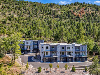 Discover modern living in this stunning townhouse development nestled against a lush, tree-covered hillside.