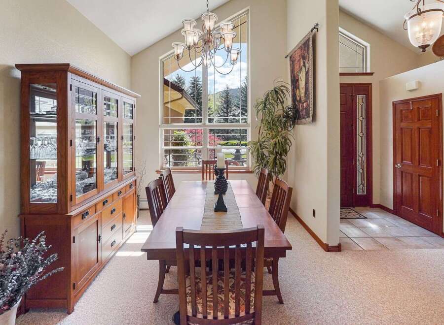 This elegant dining room boasts a stunning chandelier and a large window offering breathtaking views.