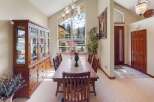 This elegant dining room boasts a stunning chandelier and a large window offering breathtaking views.