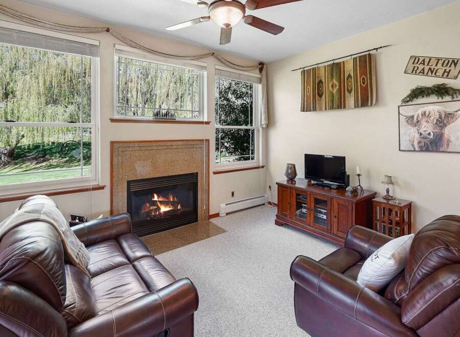 Cozy up in this inviting living room, featuring a warm fireplace and comfortable leather seating.