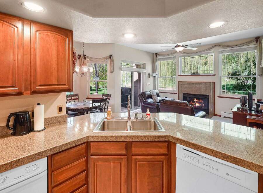 This stunning kitchen boasts beautiful wooden cabinetry and granite countertops, creating a warm and inviting atmosphere.
