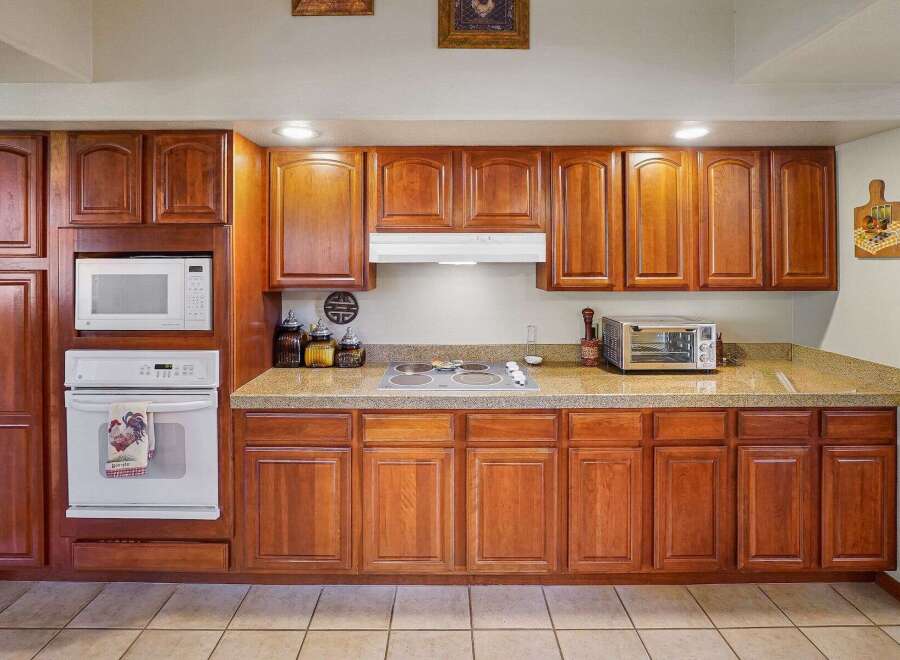 This kitchen boasts beautiful wooden cabinetry, offering ample storage space and a warm, inviting atmosphere.