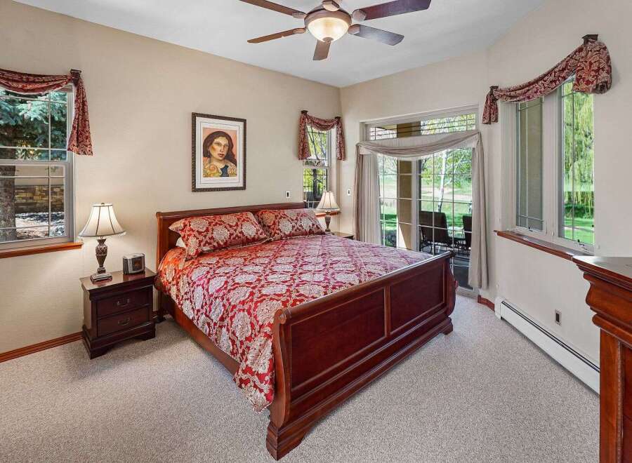 Step into this elegant bedroom featuring a luxurious bed with a rich, patterned comforter.