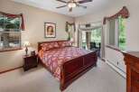 Step into this elegant bedroom featuring a luxurious bed with a rich, patterned comforter.