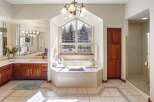 This luxurious bathroom boasts a stunning design with a large soaking tub, perfect for relaxation.
