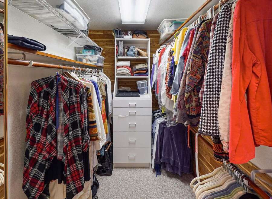 Step into your dream closet! This spacious walk-in closet offers ample storage with built-in shelving and drawers, perfect for organizing your wardrobe.