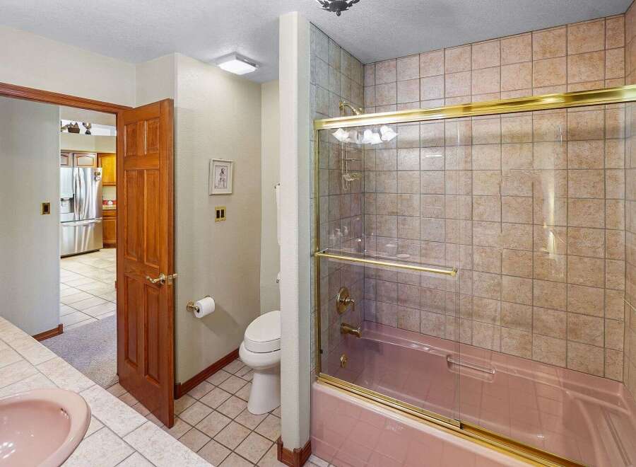 Step into this inviting bathroom featuring a stylish pink bathtub and shower combination.