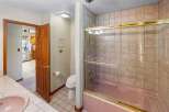 Step into this inviting bathroom featuring a stylish pink bathtub and shower combination.