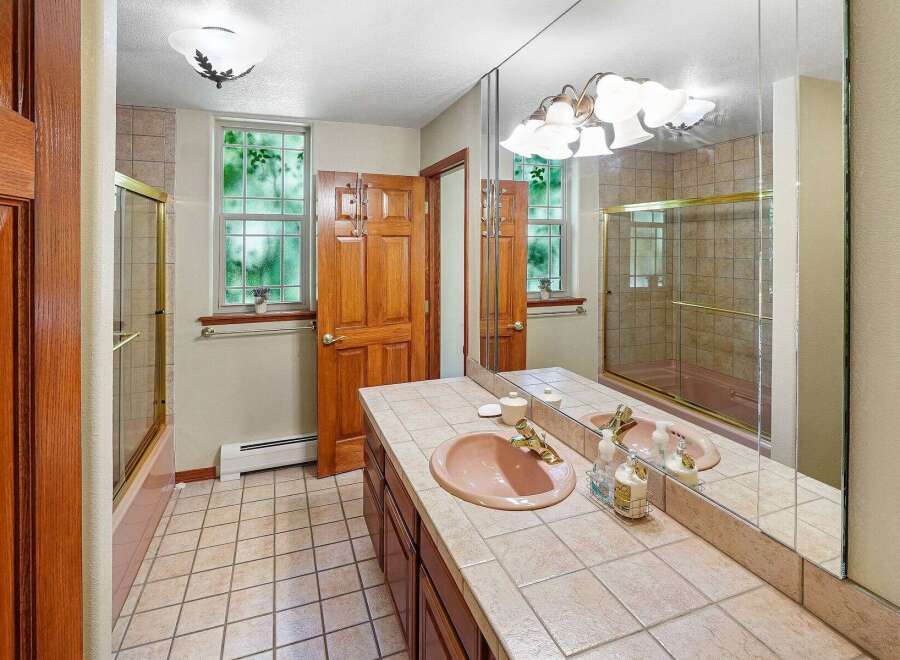 Step into this inviting bathroom featuring a stylish vanity with a unique pink sink.