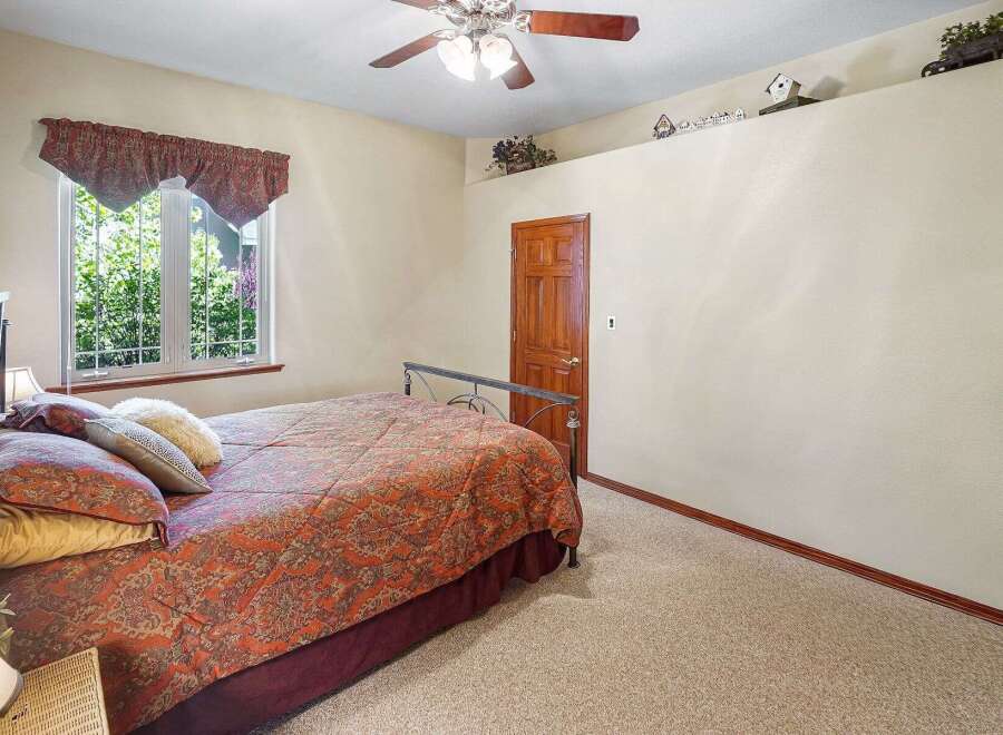 This inviting bedroom features a comfortable bed with a patterned comforter and decorative pillows, creating a cozy atmosphere.