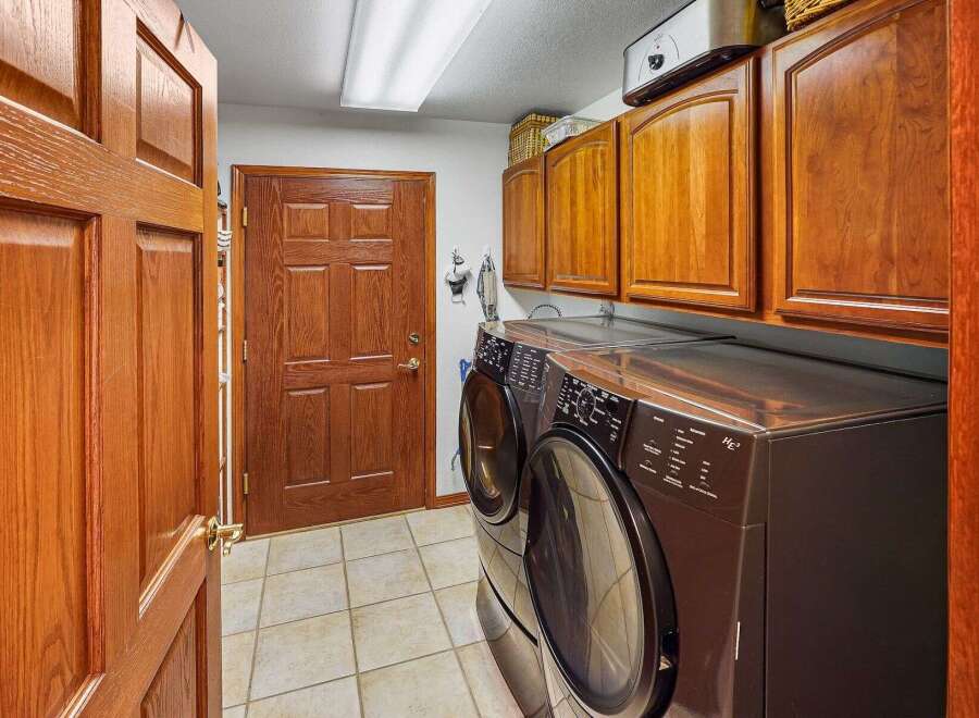 Step into this inviting laundry room, featuring a modern washer and dryer set.