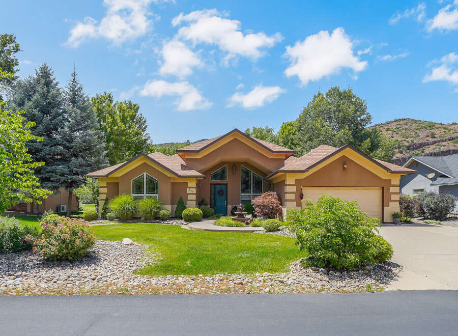 Discover this stunning home featuring a warm stucco exterior and a welcoming entryway with a vibrant blue door.