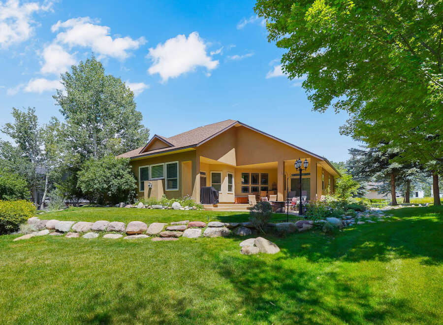 Enjoy outdoor living with this spacious backyard featuring a covered patio, perfect for entertaining.