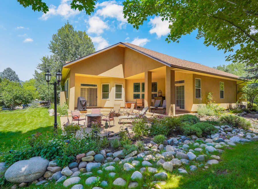 Enjoy outdoor living in this stunning backyard featuring a spacious patio with a fire pit and comfortable seating, perfect for gatherings.