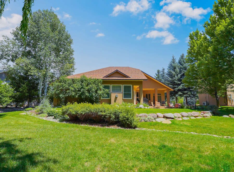 Discover this charming home featuring a spacious backyard perfect for outdoor entertaining, complete with a covered patio and lush green lawn.