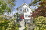 Charming two-story home with a vibrant red front door, offering a welcoming entrance.