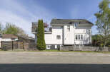 This stunning property boasts a modern design with a crisp white exterior and a charming balcony.