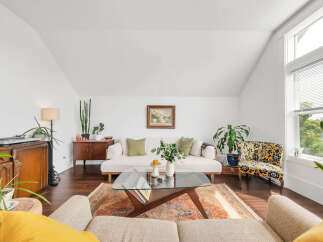 This stunning living room boasts a bright and airy atmosphere with its vaulted ceilings and ample natural light.