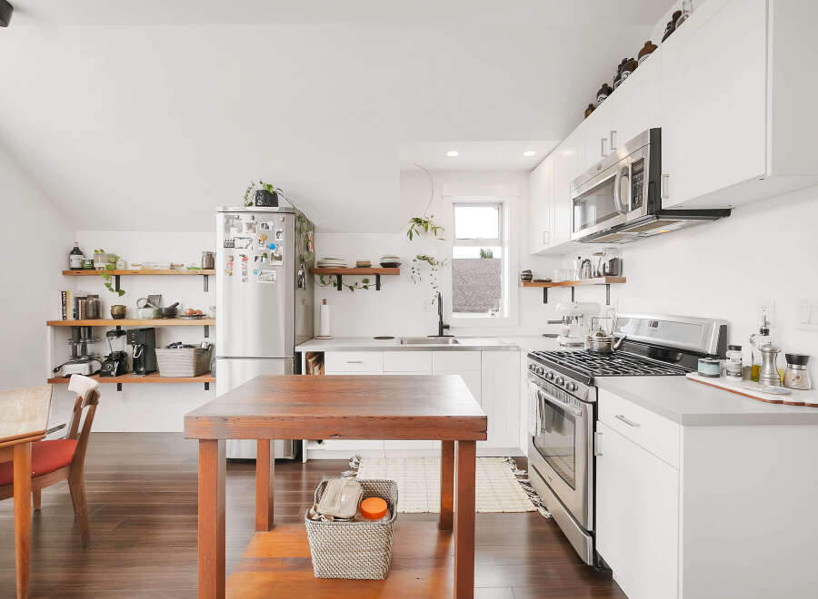 This stunning kitchen boasts a modern design with sleek white cabinetry and stainless steel appliances.