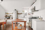 This stunning kitchen boasts a modern design with sleek white cabinetry and stainless steel appliances.