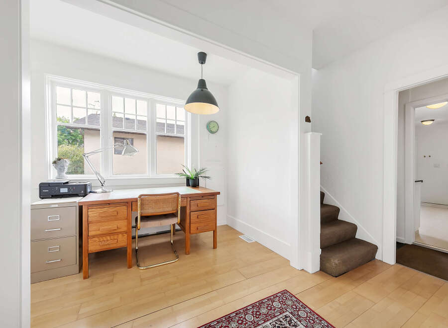 This bright and airy home office features a large window that floods the space with natural light.