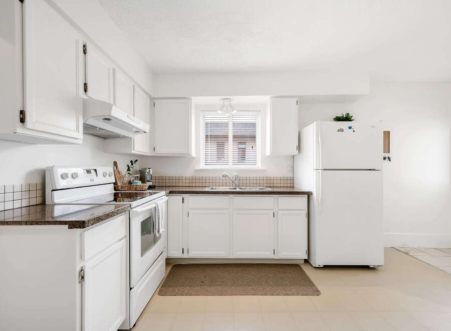 This bright and airy kitchen features white cabinetry, offering a clean and modern aesthetic.