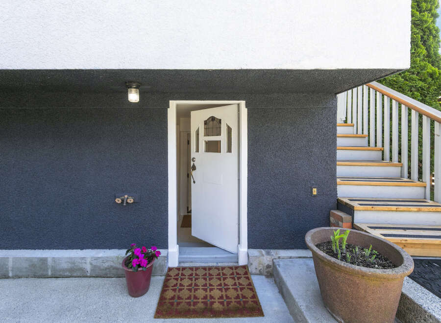 This charming home boasts a welcoming entrance with a stylish front door and a cozy doormat.