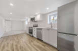 This stunning kitchen boasts modern appliances and sleek white cabinetry, perfect for culinary enthusiasts.