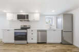 This modern kitchen boasts sleek white cabinetry, stainless steel appliances, and a stylish design.