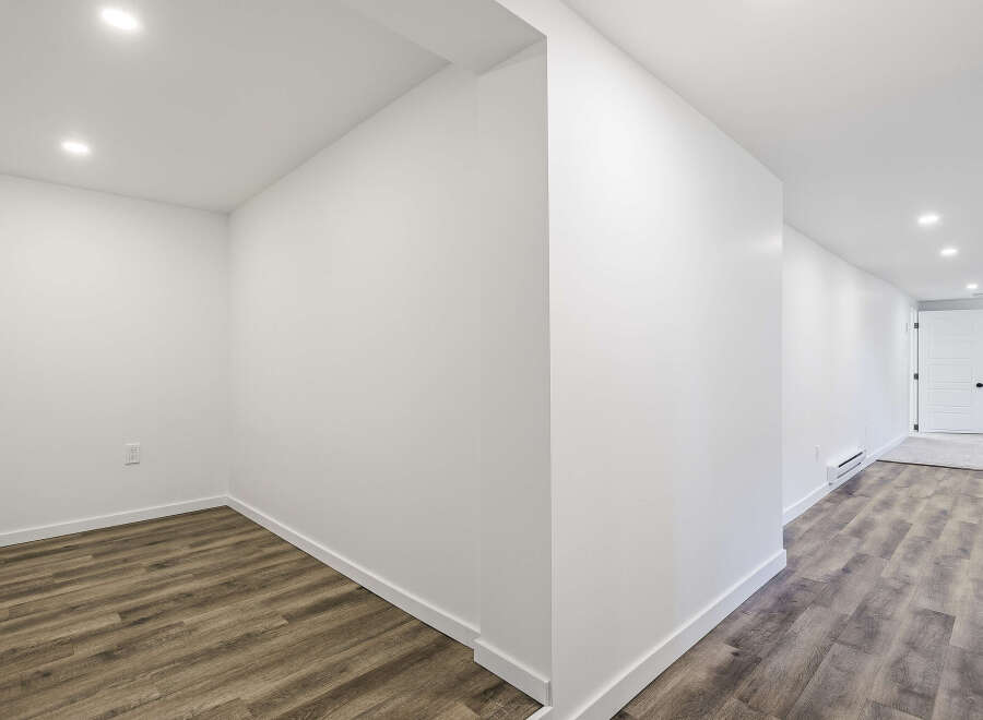 Discover the potential of this beautifully designed space! Featuring a modern aesthetic with pristine white walls and recessed lighting, this area offers a bright and inviting atmosphere.