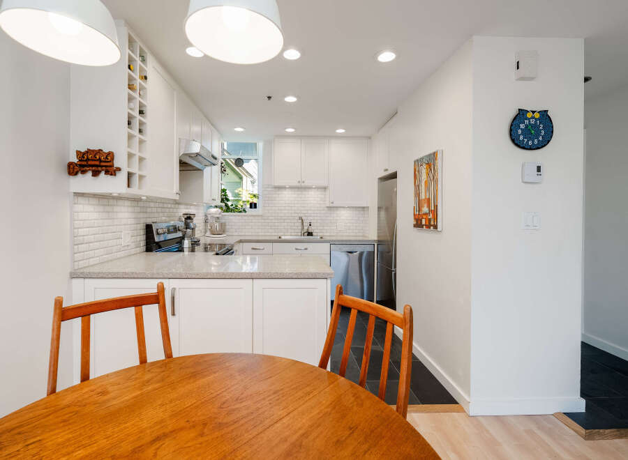 This stunning kitchen boasts a modern design with sleek white cabinetry and a beautiful countertop.