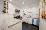 This stunning kitchen boasts a modern design with sleek white cabinetry and a beautiful granite countertop.