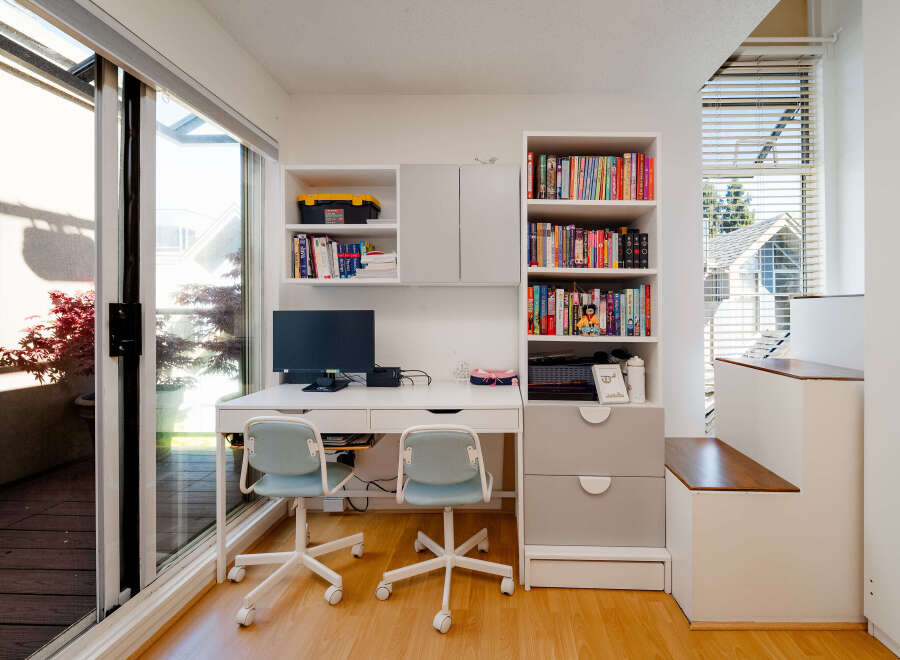 This bright and airy home office features a modern desk setup with two comfortable chairs, perfect for working or studying.