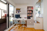This bright and airy home office features a modern desk setup with two comfortable chairs, perfect for working or studying.