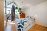 This bright and airy bedroom features a modern design with a large window that floods the space with natural light.