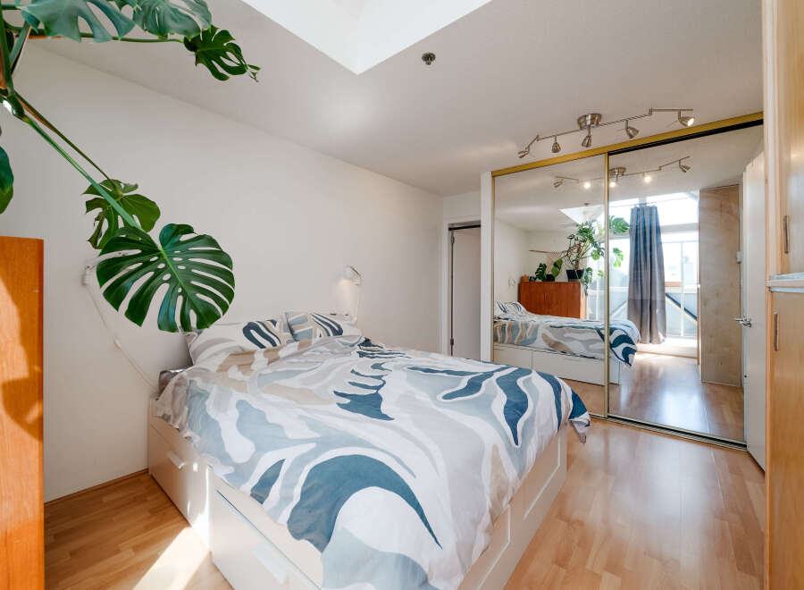 This bright and airy bedroom features a modern design with a large bed and ample natural light.