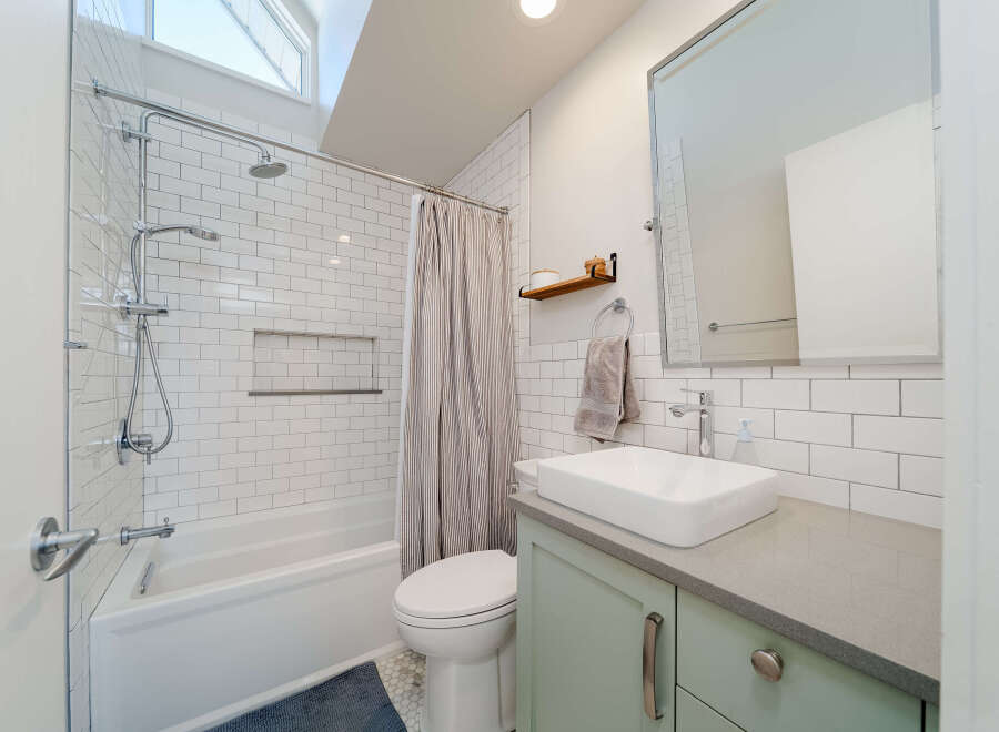 This modern bathroom features a sleek design with white subway tiles and a contemporary vanity.