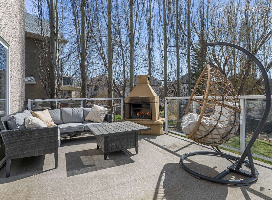 Enjoy outdoor living at its finest with this stunning patio space! Featuring a cozy seating area, a stylish coffee table, and a unique hanging chair, perfect for relaxation.
