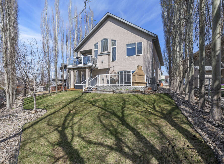 This stunning property boasts a beautiful exterior with a well-maintained lawn and mature trees.