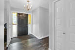 Step into this inviting entryway, featuring a stylish black front door and elegant chandelier.