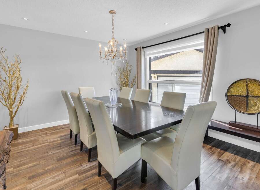 Step into luxury with this stunning dining room! Featuring a dark wood dining table and elegant white chairs, this space is perfect for hosting dinner parties.