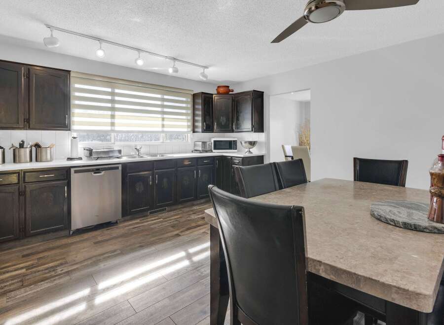This stunning kitchen boasts dark wood cabinetry, stainless steel appliances, and a stylish track lighting system.