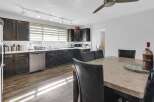 This stunning kitchen boasts dark wood cabinetry, stainless steel appliances, and a stylish track lighting system.