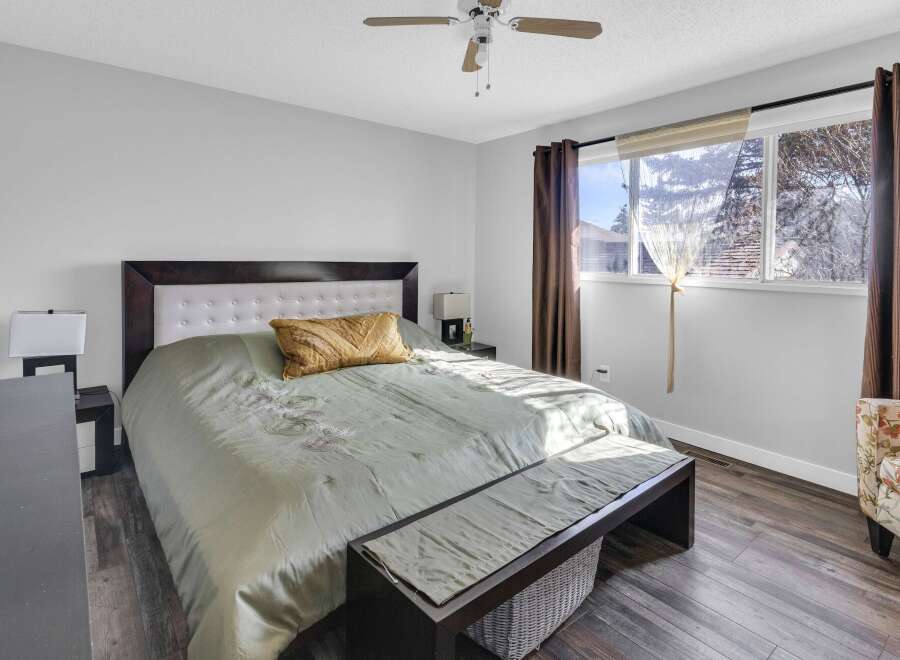 This inviting bedroom showcases a comfortable bed with a stylish headboard and a cozy bench at the foot.