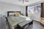 This inviting bedroom showcases a comfortable bed with a stylish headboard and a cozy bench at the foot.